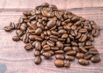 Roasted coffee beans over rustic wooden background
