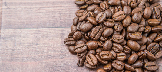 Roasted coffee beans over rustic wooden background
