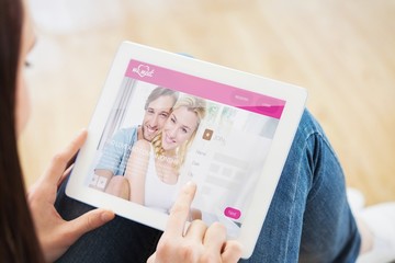 Composite image of teen using a tablet pc sitting on the floor