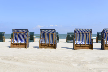 Empty sunbathing chairs on the beach.