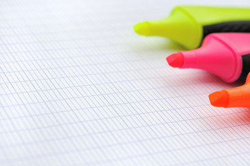 surligneurs fluo sur feuilles quadrillée