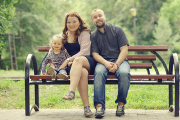 Mom and young daughter and dad, a young family on a walk in the park in summer