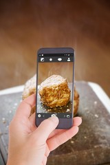 Composite image of female hand holding a smartphone