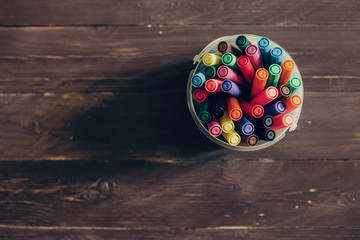 Top view, colorful felt pens on dark wooden table. Toned photo, shallow depth of field. - Powered by Adobe