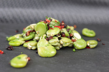 Closeup of broad beans, bacon and chili salad.