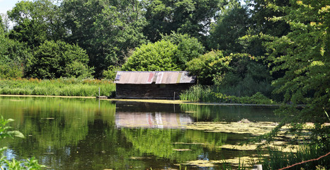 Fototapeta na wymiar Lake and rustic Boathouse on the river misbourne in Buckinghamshire