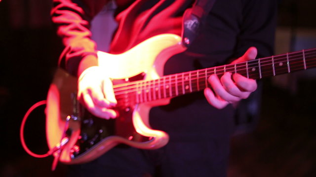 Man professionally playing electric guitar on a stage.Close-up footage
