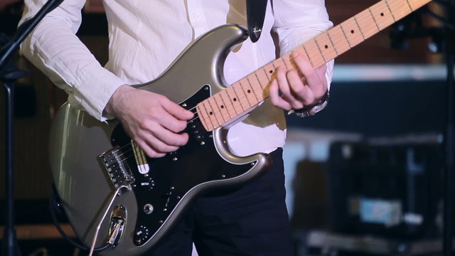 Man playing electric guitar on a stage.Close-up footage