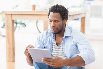 Young creative businessman scrolling on the tablet