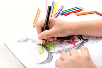 Detail of child coloring on white paper