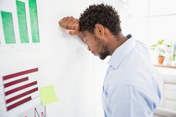 Obraz premium Thinking business man in the office leaning against the wall 