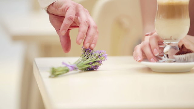  Mans hand lays down a bouquet of lavender on the table.