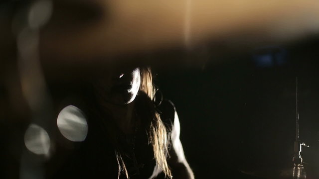 Drummer of black metal band. Close up dark background