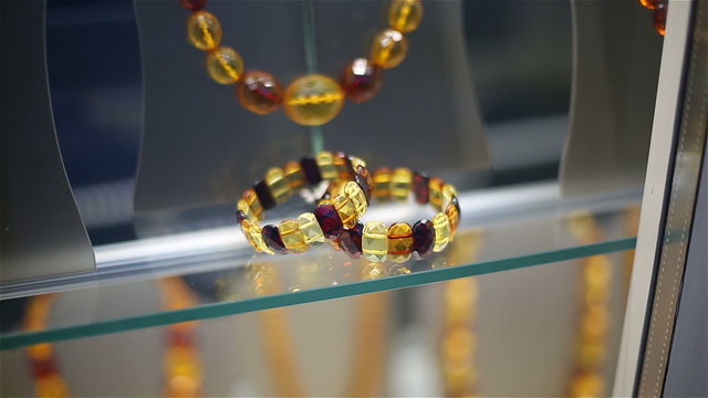 Amber beads and bracelets on a show-window of shop of jewelry