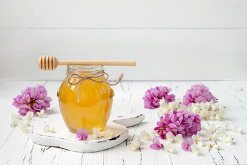 Robinia honey with acacia blossoms on old wooden table