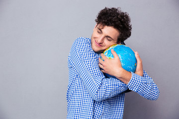 Young man hugging globe