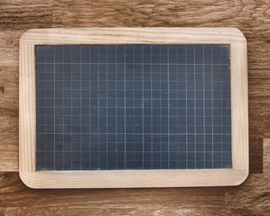 ardoise avec quadrillage sur fond en bois 
