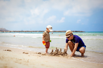 father and son build sand castle