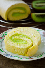 Roll cake with kiwi cream decorated macarons