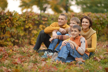 Family relaxing in autumn park