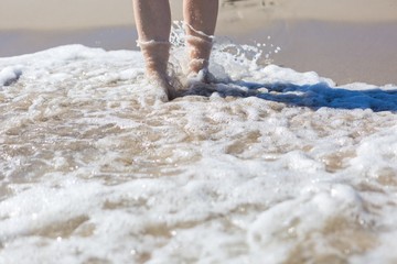 Close up of woman foot walking by sea shore