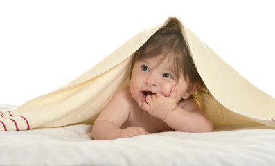 Baby girl lying under blanket