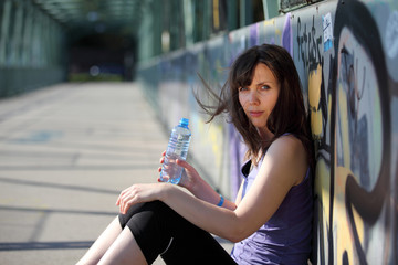 Young woman drinks some water after sports