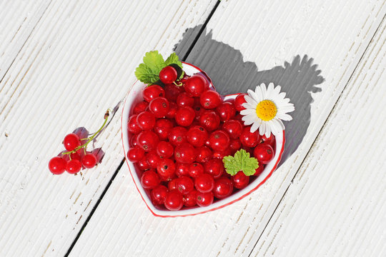 currant in a heart box on  wooden table