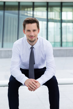 Businessman sitting on the blench