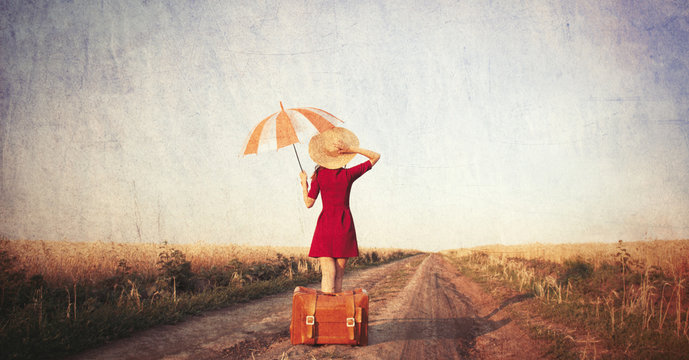 Redhead girl with suitcase and umbrella