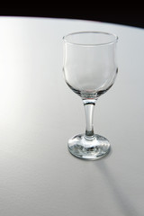 Empty wineglass stands on white round table