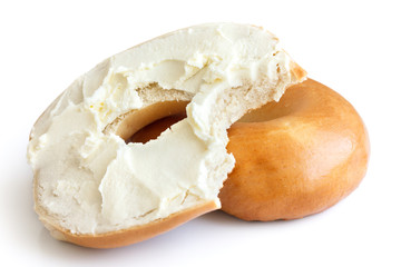 Plain bagel spread with cream cheese and bite missing. Isolated.