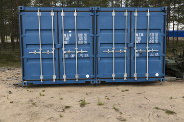 Two containers atteched to each other on a sand field 