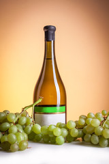 Obraz premium White wine in bottle and glass and a bunch of white grapes isolated on white
