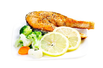 Grilled salmon with steamed vegetables on plate isolated on whit