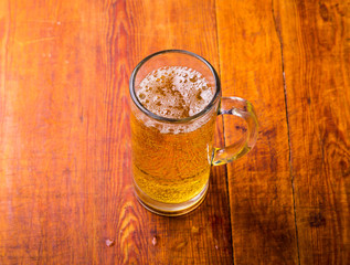 Mug of beer on wooden background