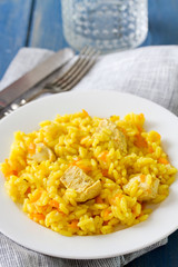 rice with meat and carrot on white plate and glass of water