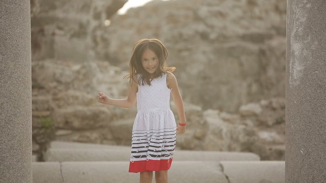 Child jumps on the stone ruins of the Roman era