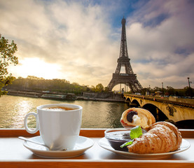 Fototapeta premium Coffee with croissants against Eiffel Tower in Paris, France