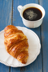 croissant in dish with cup of coffee