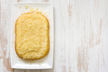 baked pasta with cheese on white dish on white wooden background