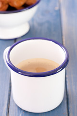 cup of coffee with milk and cookies on blue wooden background