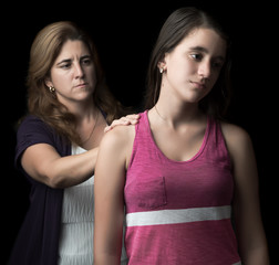 Sad teen girl with her mother offering help