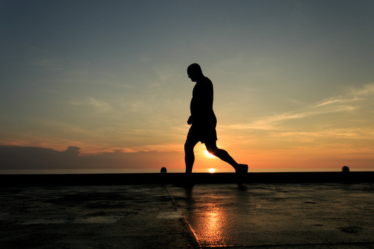 Silhouette Image of man walking on the helideck in the evening 