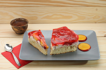 Strawberry and peach cake with gelatin on grey plate on wooden t