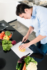 Japanese man preparing salad and cooking in kitchen