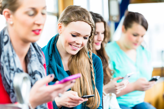 Fahrgäste in Straßenbahn beim Chatten mit Handy