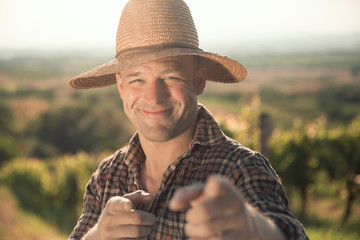 Portrait of male vintner with hat posing at vineyard