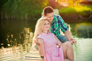 Young beautiful  stylish couple in love sitting  near the river