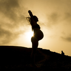 pregnant woman's silhouette in the sunset